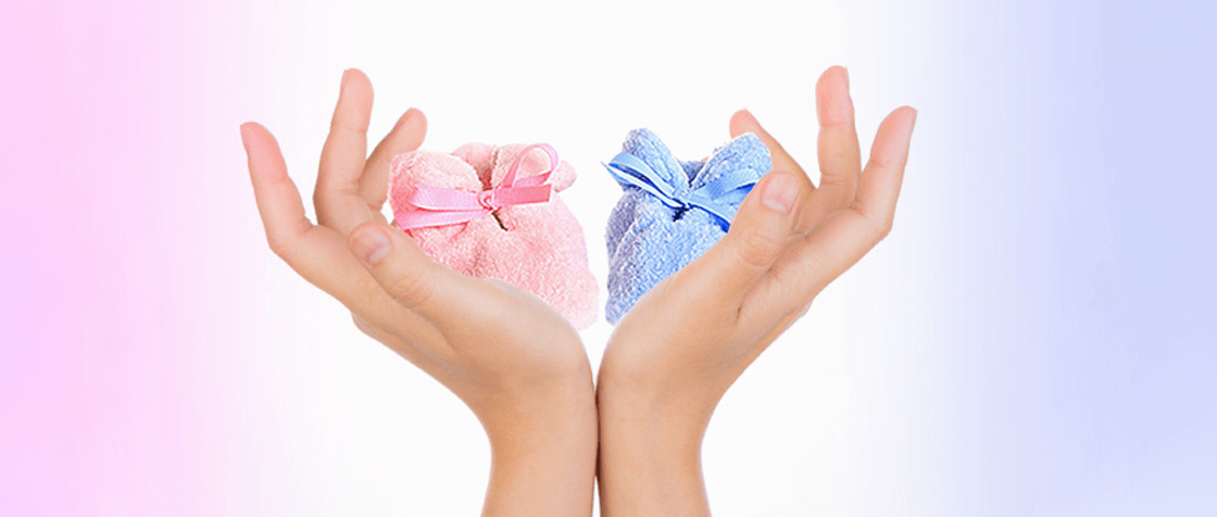 two female hands are holding baby blue and baby pink wrapped towel
