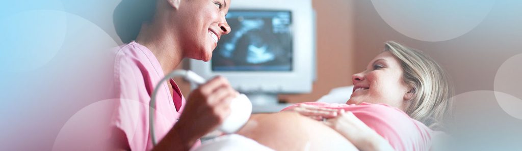 Female doctor is doing an ultrasound examination of a pregnant woman and determines the gender of her child